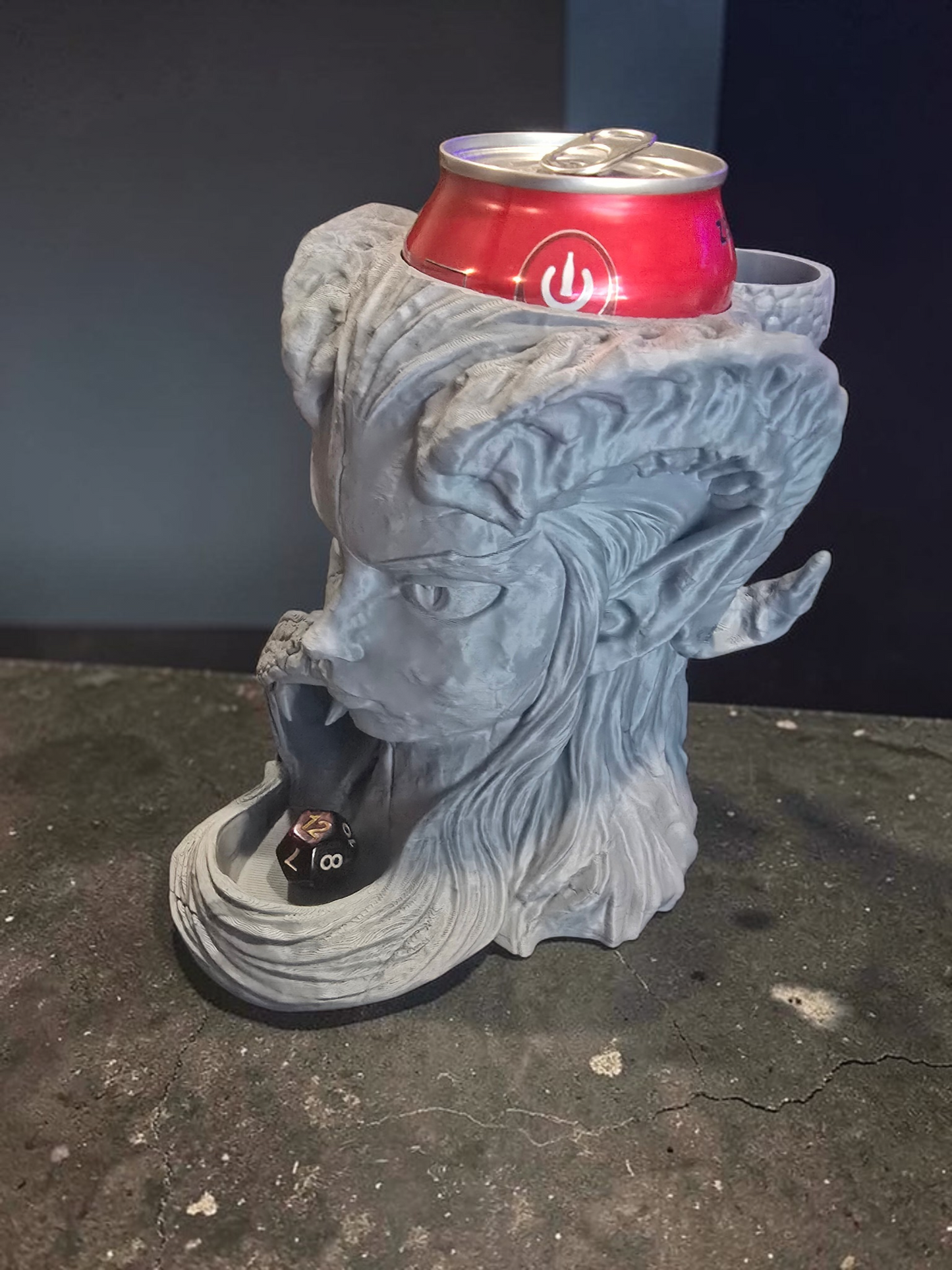 Statue of a dragon head with a can on its head against a dark background