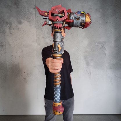 Person holding a large, colorful fantasy-style weapon against a plain background